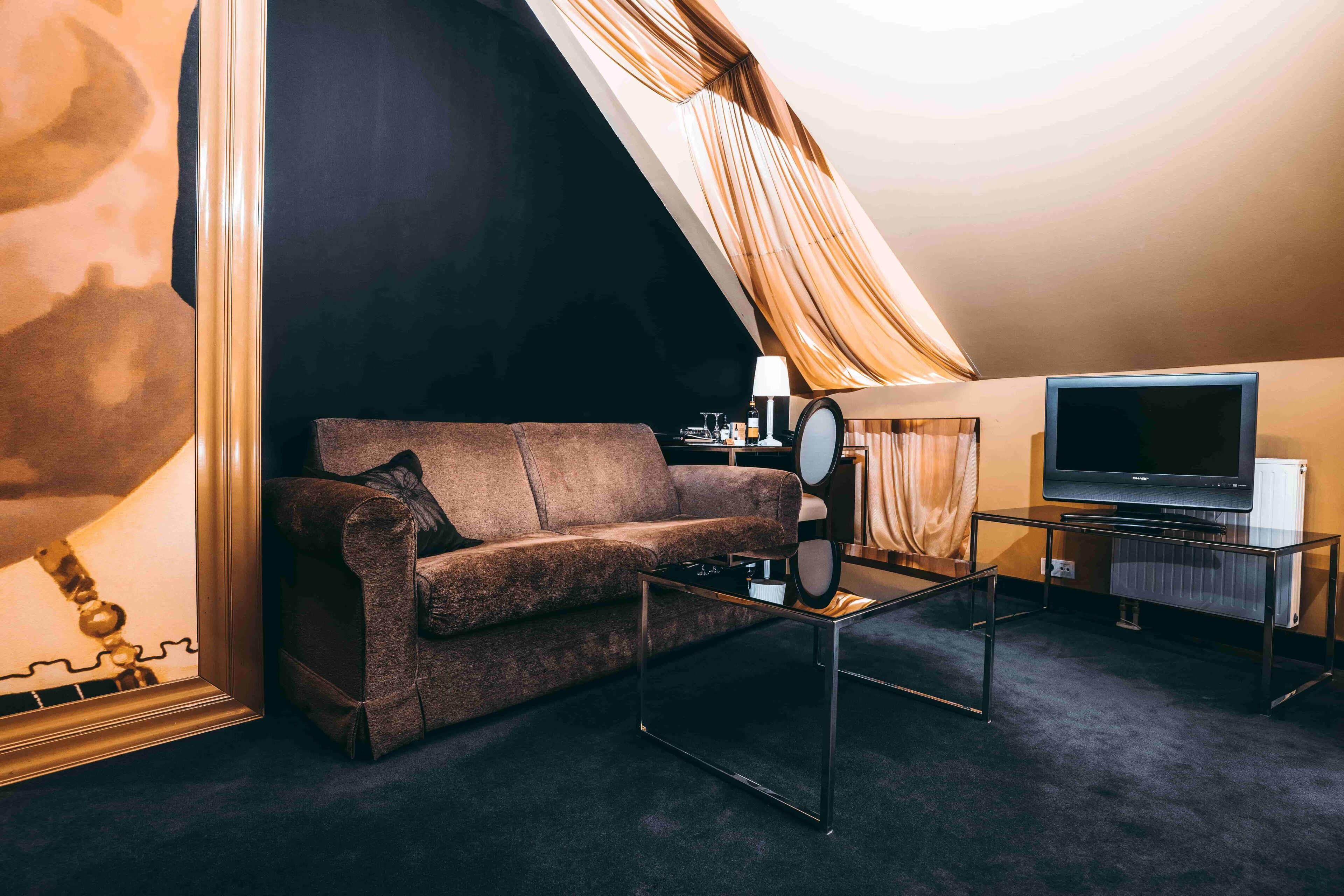 Een moderne woonkamer met een bank, een salontafel, een televisie en een lamp.