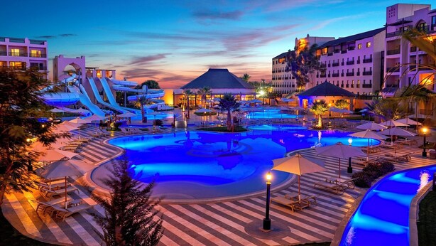 Un resort con una gran piscina, parque acuático y un edificio de hotel.