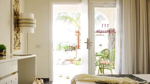Habitación de hotel con cama, escritorio, silla y vistas al exterior.