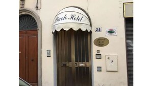 A hotel entrance with a sign reading "Piccolo Hotel" above a wooden door. - Piccolo Hotel (Florence)