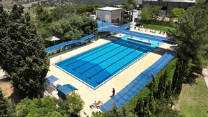 Una gran piscina al aire libre con vistas a un paisaje urbano de fondo.