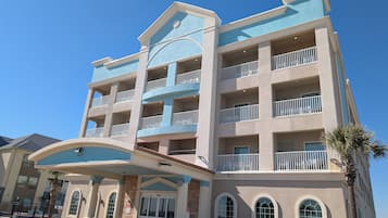 Un hotel de varios pisos con un atrio central, balcones y fachada de piedra.