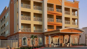 Un hotel de varios pisos con balcones, fachada de piedra y entrada cubierta.