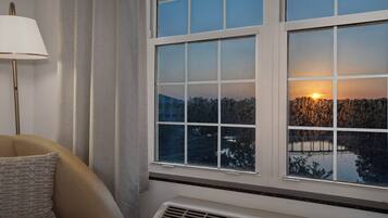 A room with a window, a lamp, and a couch.