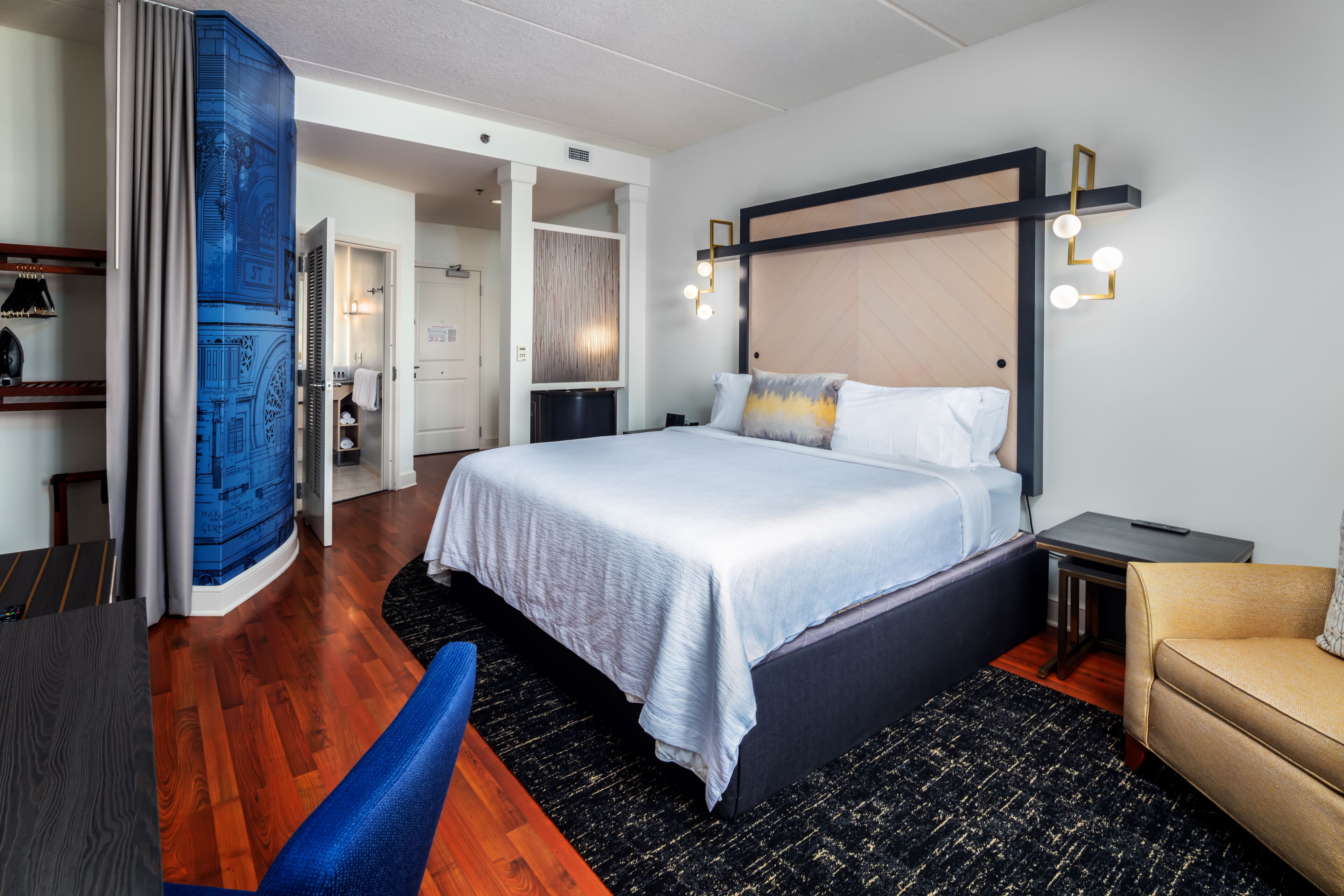 Une chambre d’hôtel moderne dotée d’un grand lit, d’un bureau et d’un coin salon.
