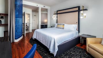 Une chambre d’hôtel moderne dotée d’un grand lit, d’un bureau et d’un coin salon.