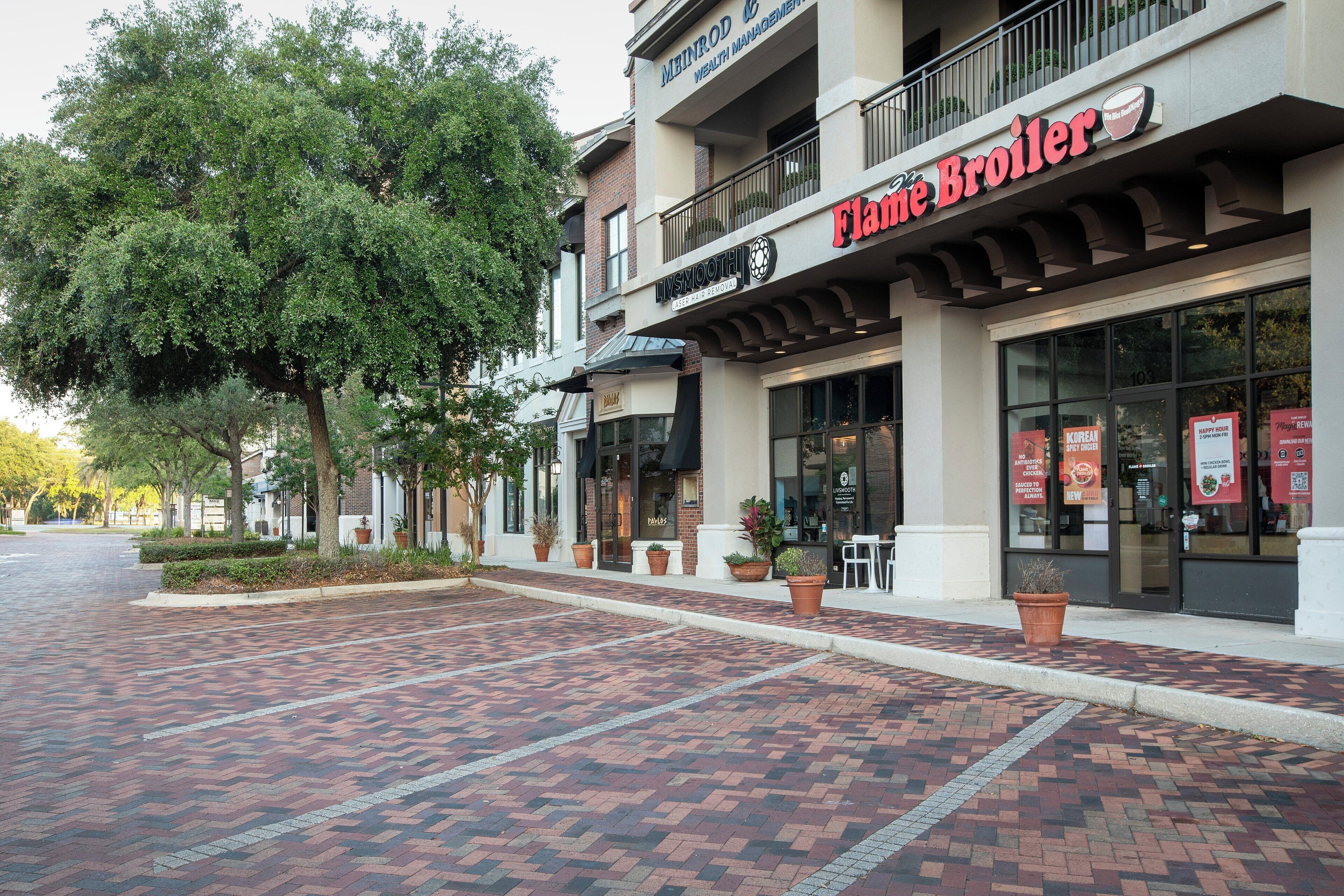 A building with a storefront named 'Flame Broiler' and 'INSMOOTH Wealth Management'.