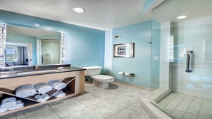 A modern bathroom with a glass shower enclosure, a toilet, and a vanity with towels. - Hotel Indigo Jacksonville-Deerwood Park by IHG (Jacksonville)