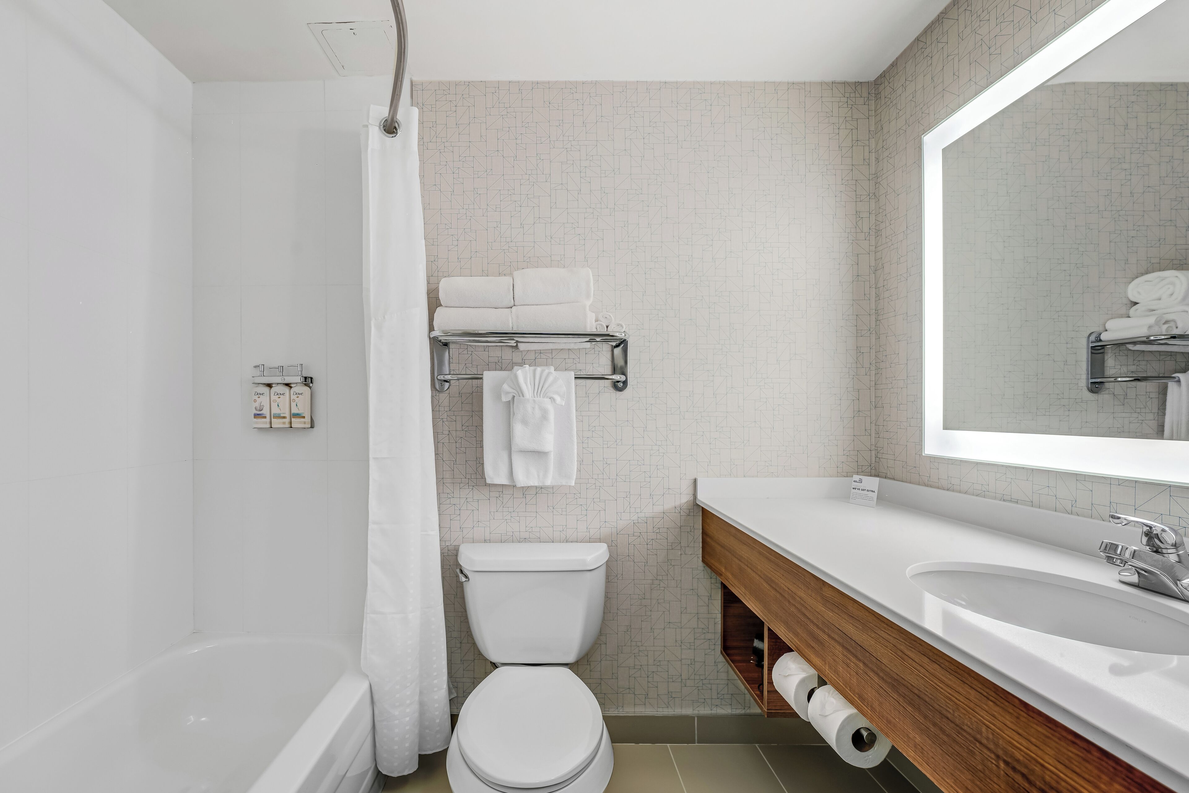Un baño moderno con inodoro, lavamanos y zona de ducha.