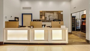 A hotel reception desk with a modern design, a blue door, and a sign above the desk. - Holiday Inn Express Hotel & Suites Edmonton South by IHG (Edmonton)