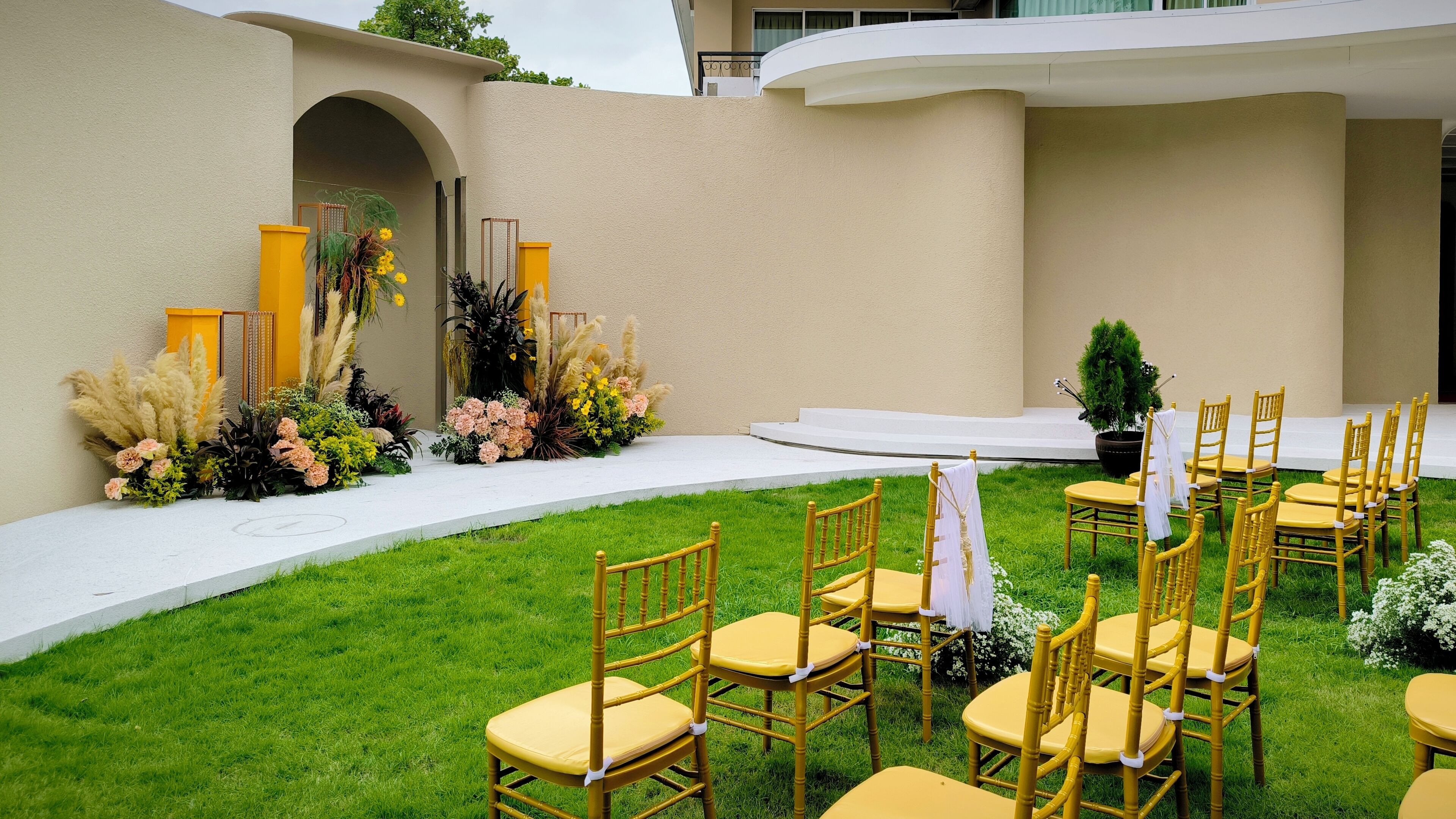 An outdoor wedding setup with chairs and floral arrangements.