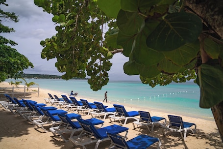 On the beach, white sand, sun loungers, beach towels. Merrils Beach Resort II