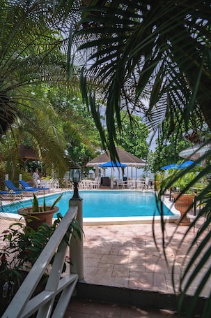 Una piscina al aire libre, sillones reclinables de piscina