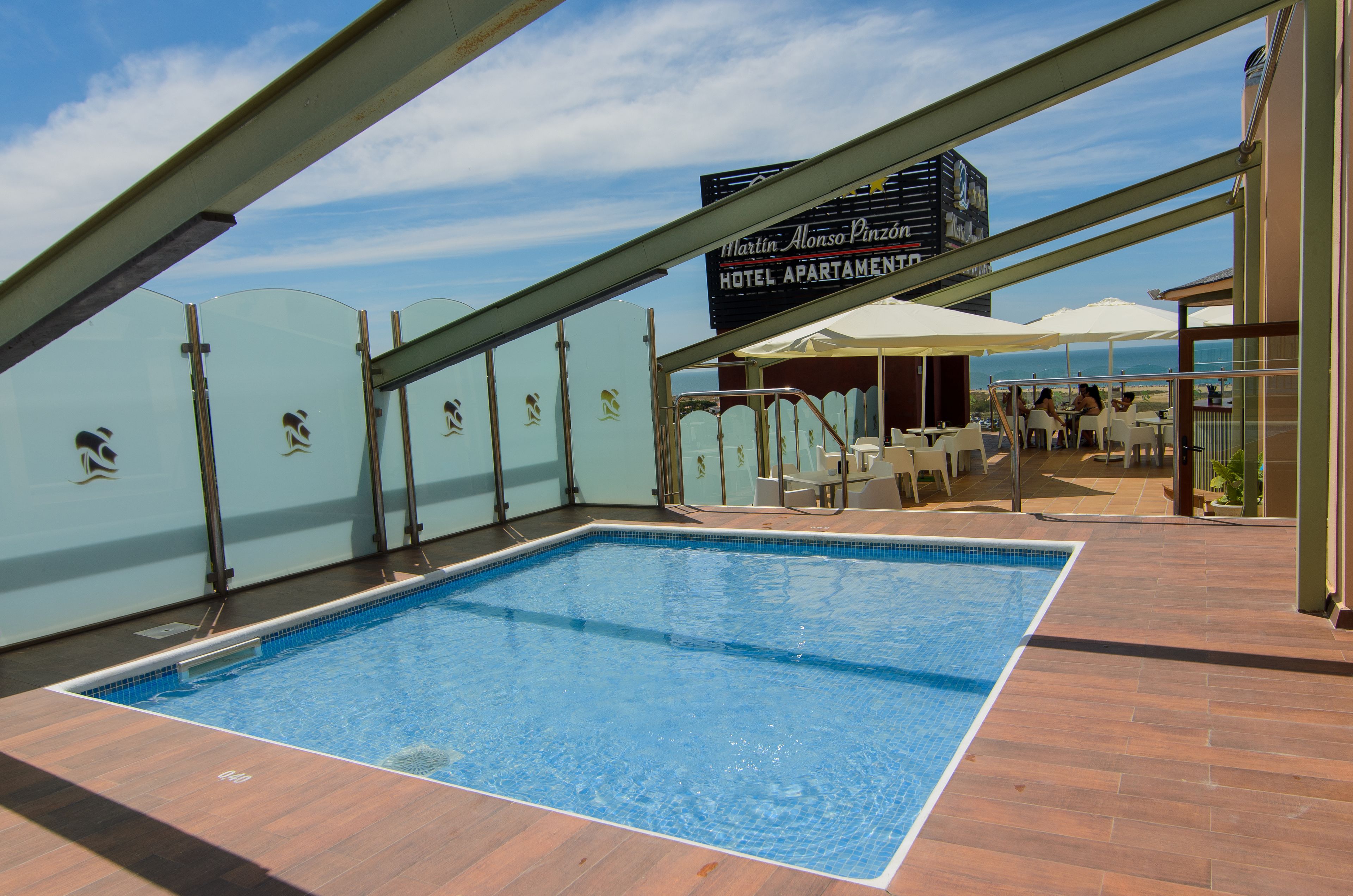 Una piscina interior con vista despejada al océano y un cartel que indica Hotel Apartado Martin Alonso Pinzón.