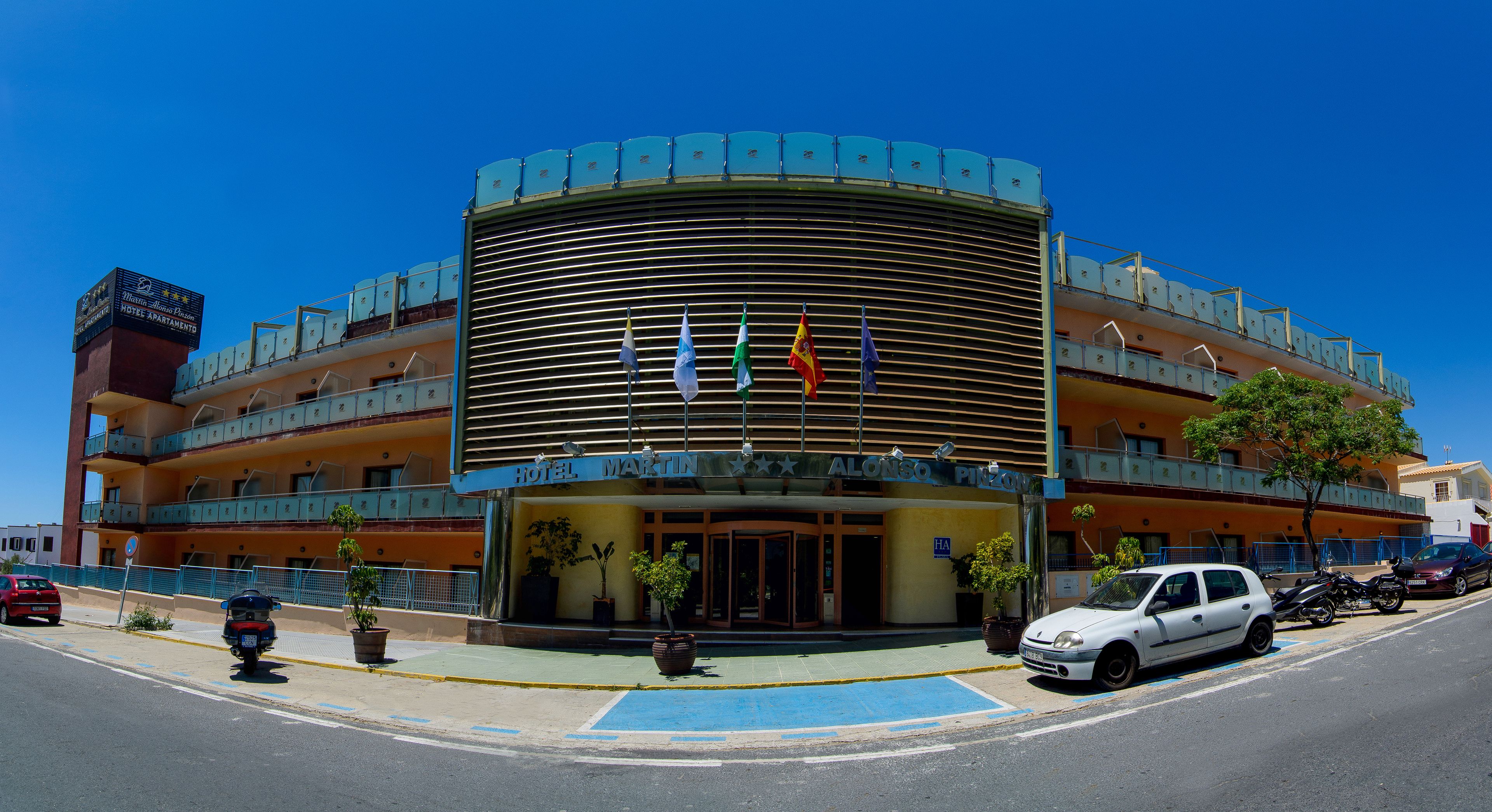 A hotel with a curved facade, multiple balconies, and a sign indicating it is a hotel.