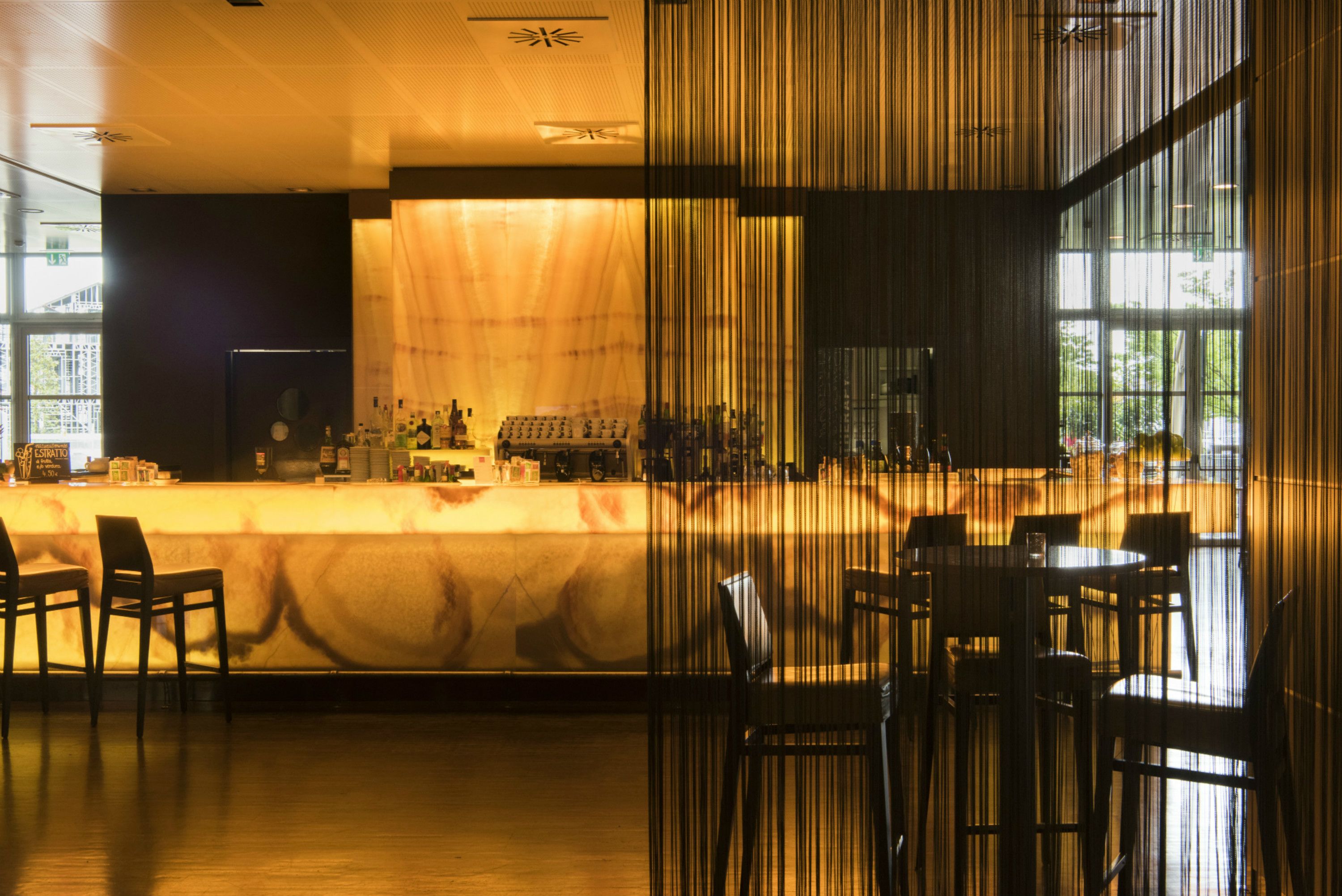 A bar area with a counter, chairs, and a large window.