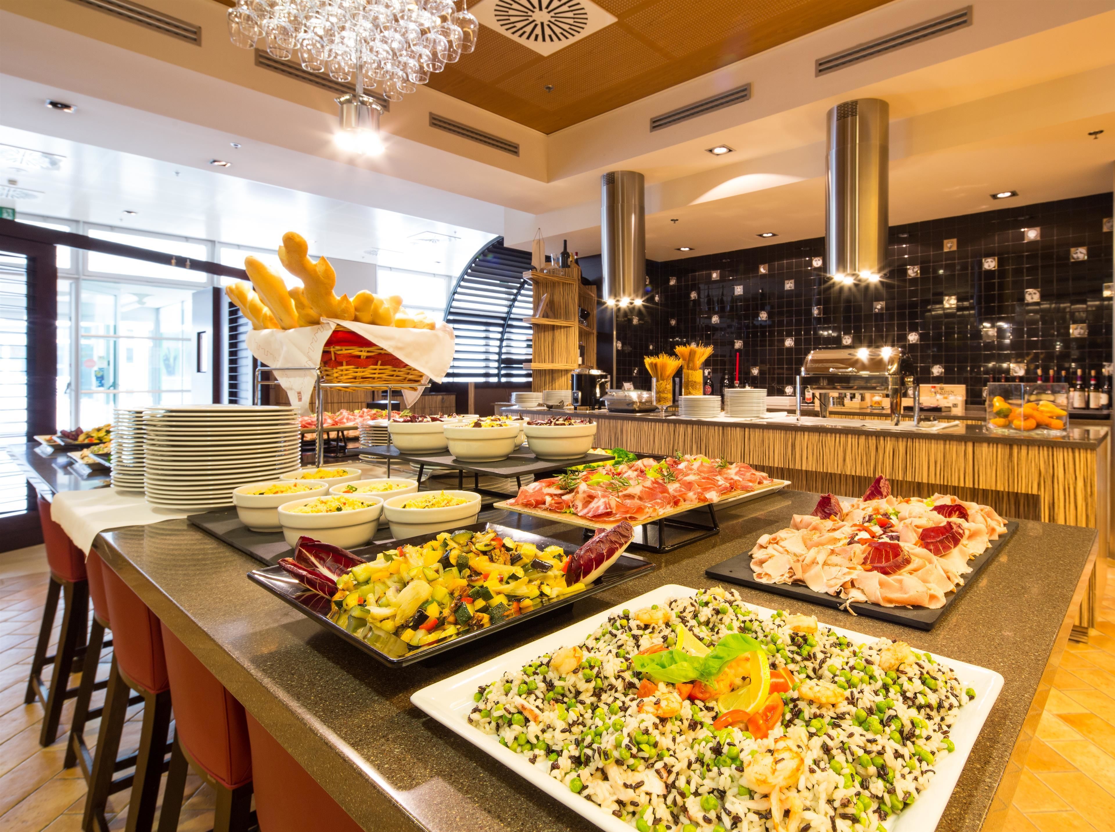 Ein Buffet mit verschiedenen Speisen, darunter Salate, Reis und Fleisch.