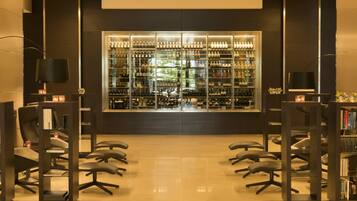 Una biblioteca con estanterías y un botellero.