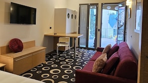 A hotel room with a bed, a desk, a chair, a sofa, and a television. - Residence Select Executive (Florence)