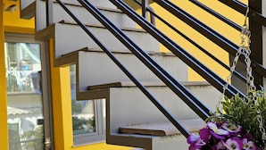 A yellow building with a metal staircase and a hanging flower pot. - Residence Select Executive (Florence)