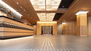 A spacious lobby with a modern design, featuring a patterned ceiling and a reception desk. - Hotel Sugicho (Kyoto)