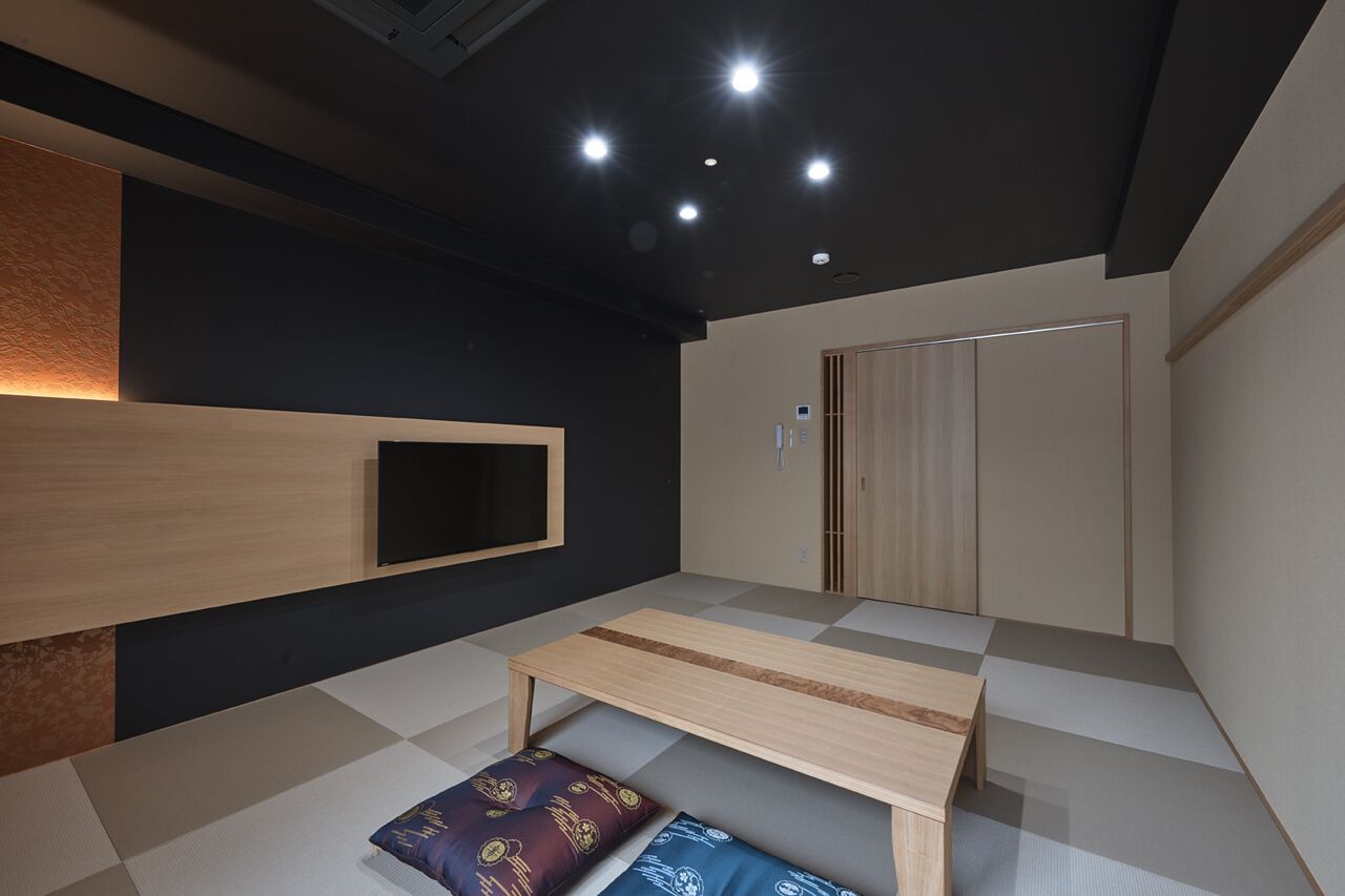A modern room with a checkered floor, a wooden bench, a wall-mounted TV, and a wardrobe.