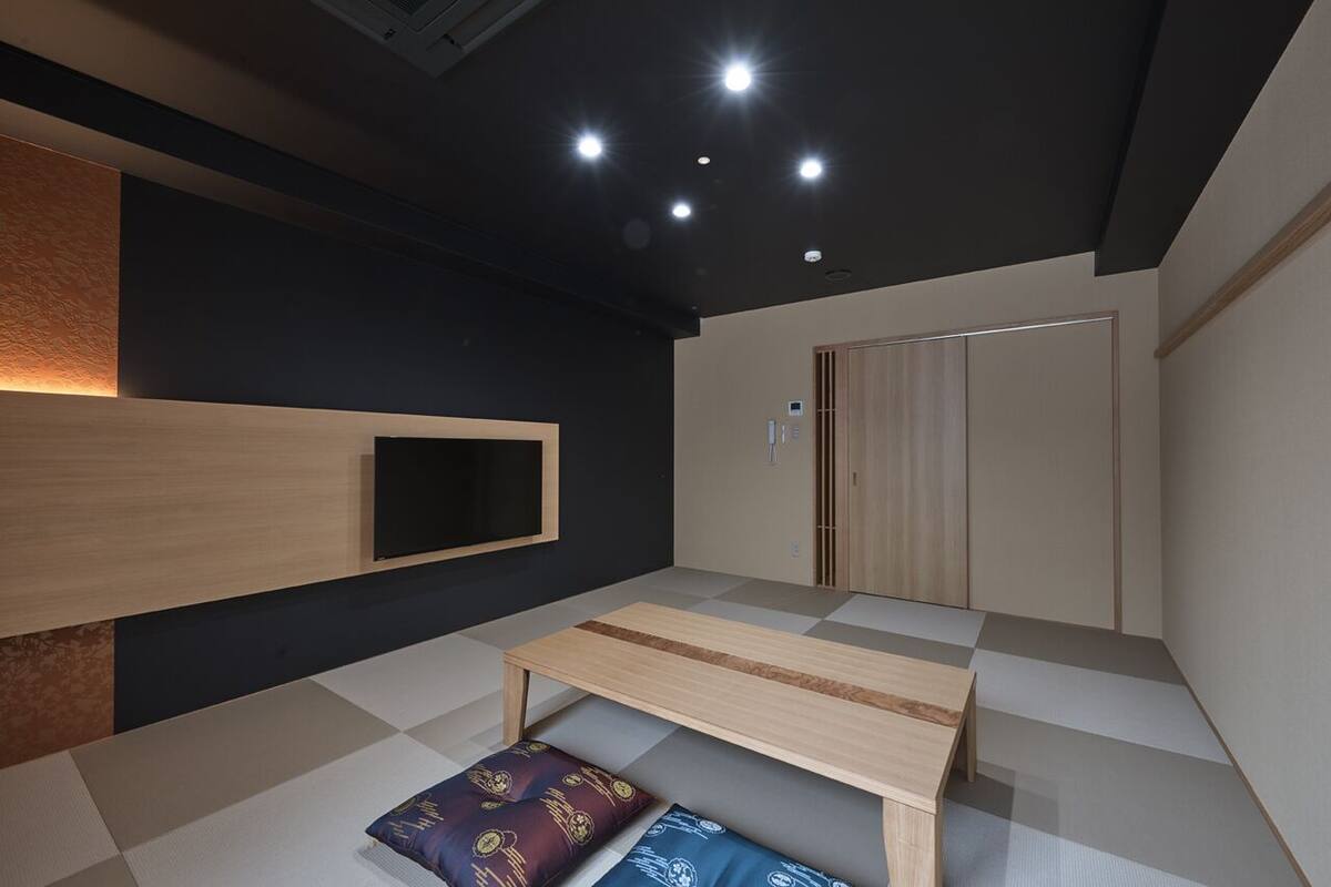 A modern room with a checkered floor, a wooden bench, a wall-mounted TV, and a wardrobe.