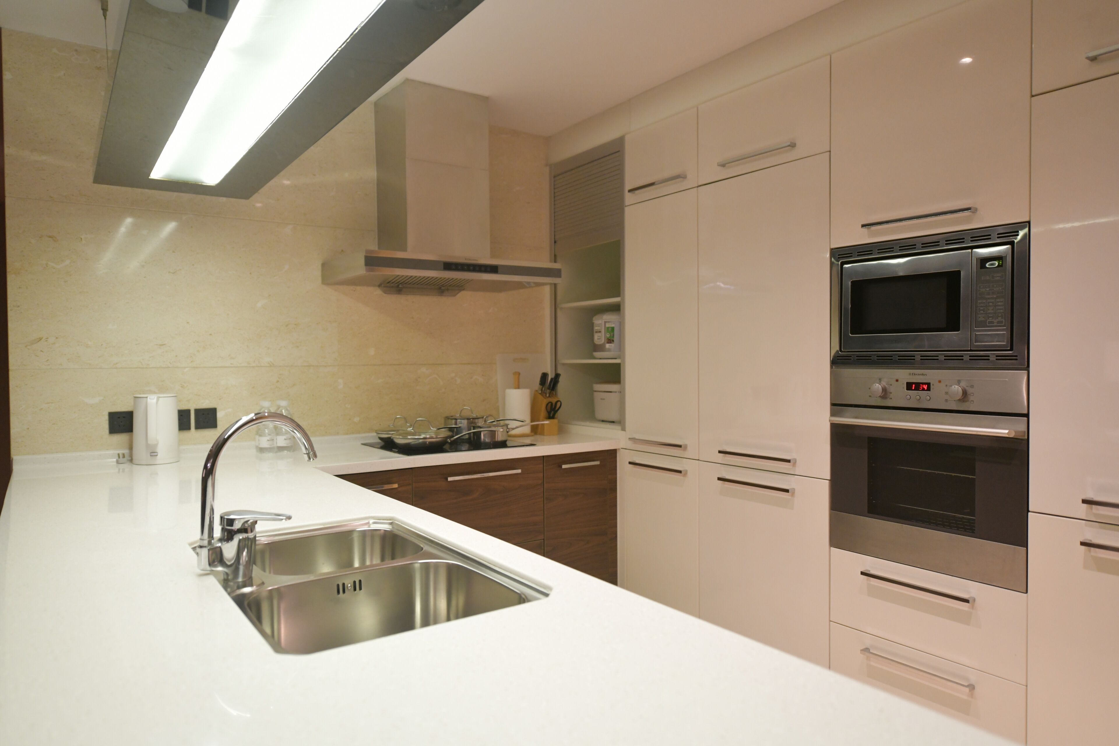 Een moderne keuken met roestvrijstalen apparatuur, een spoelbak en houten keukenkastjes.