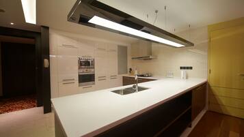 Una cocina moderna con una isla central, electrodomésticos de acero inoxidable y un armario amarillo.