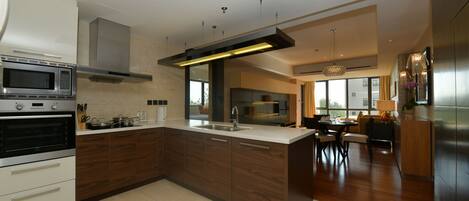A modern kitchen with a central island, built-in oven, and stainless steel appliances.