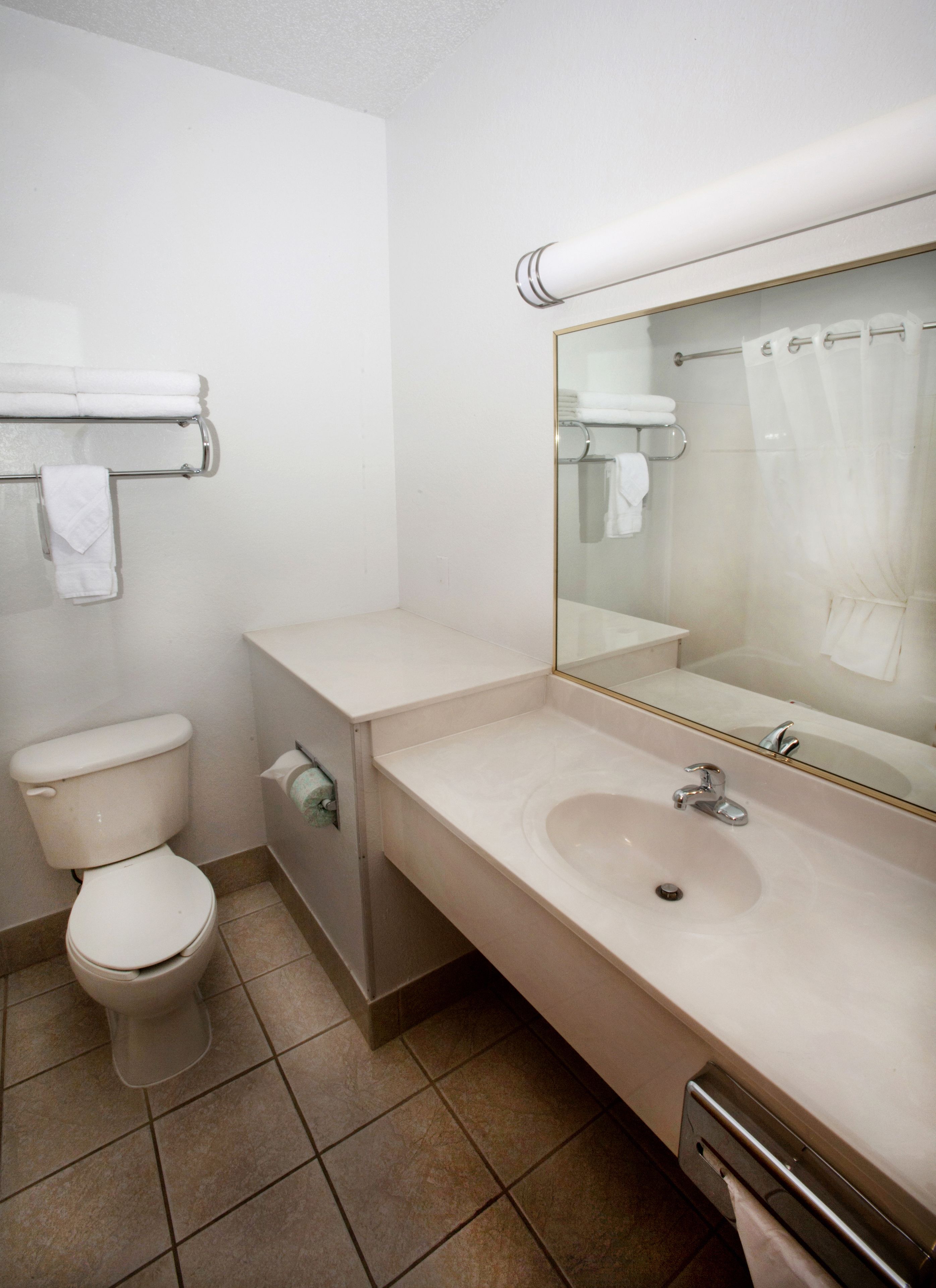 Ein Badezimmer mit Toilette, Waschbecken und Spiegel.