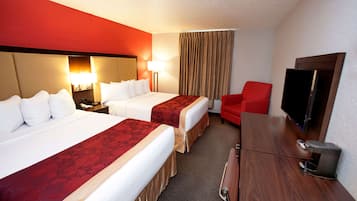 A hotel room with two beds, a TV, a desk, and a red chair.