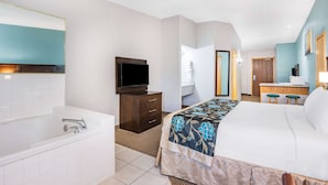 A hotel room with a large bed, a bathroom with a bathtub, a desk, and a television. - Baymont by Wyndham Keystone Near Mt. Rushmore (Keystone)