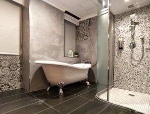 Luxe tweepersoonskamer | Badkamer | Een haardroger, pantoffels, handdoeken, shampoo