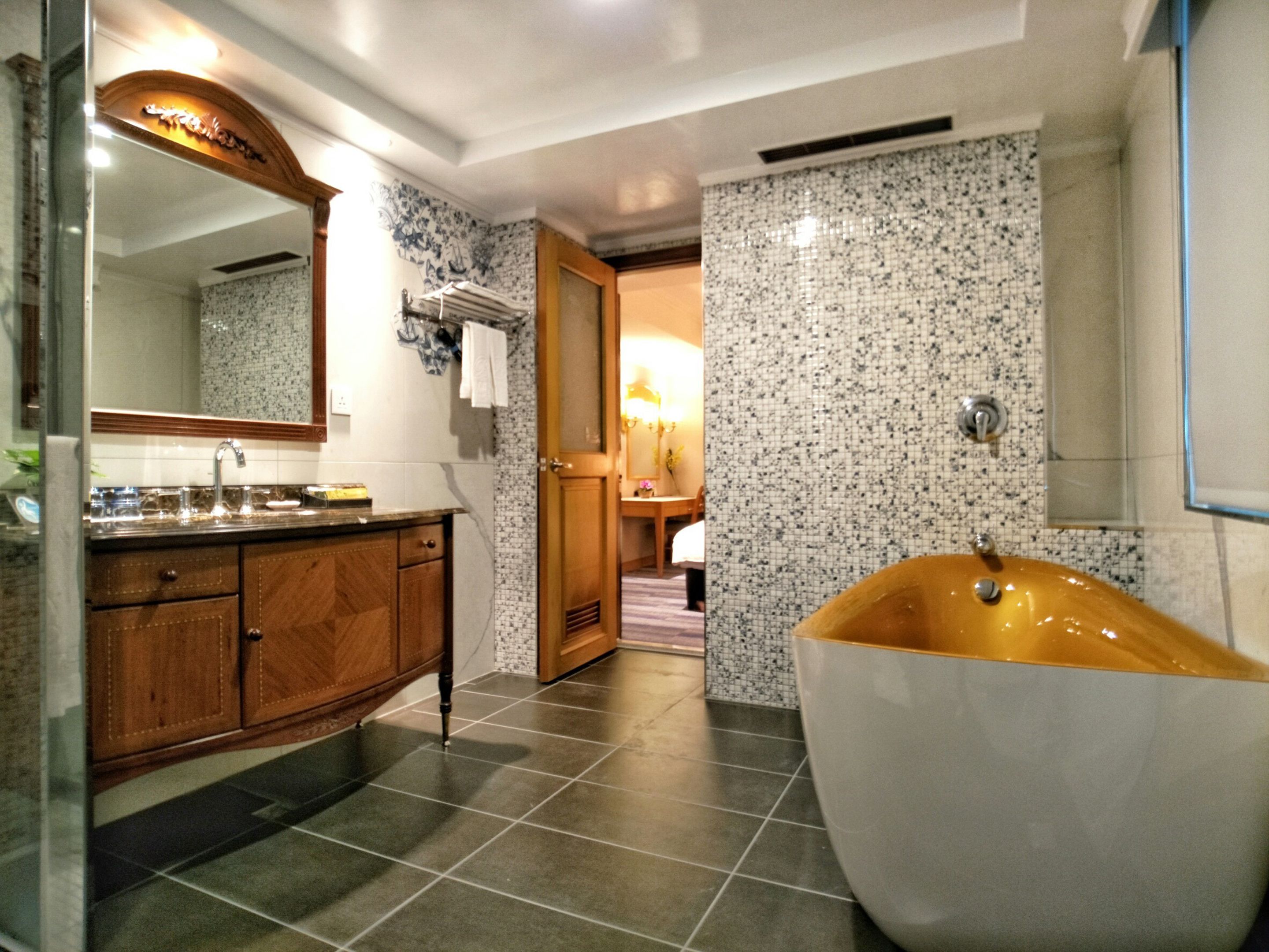 A modern bathroom with a freestanding bathtub, a wooden vanity, and a large mirror.