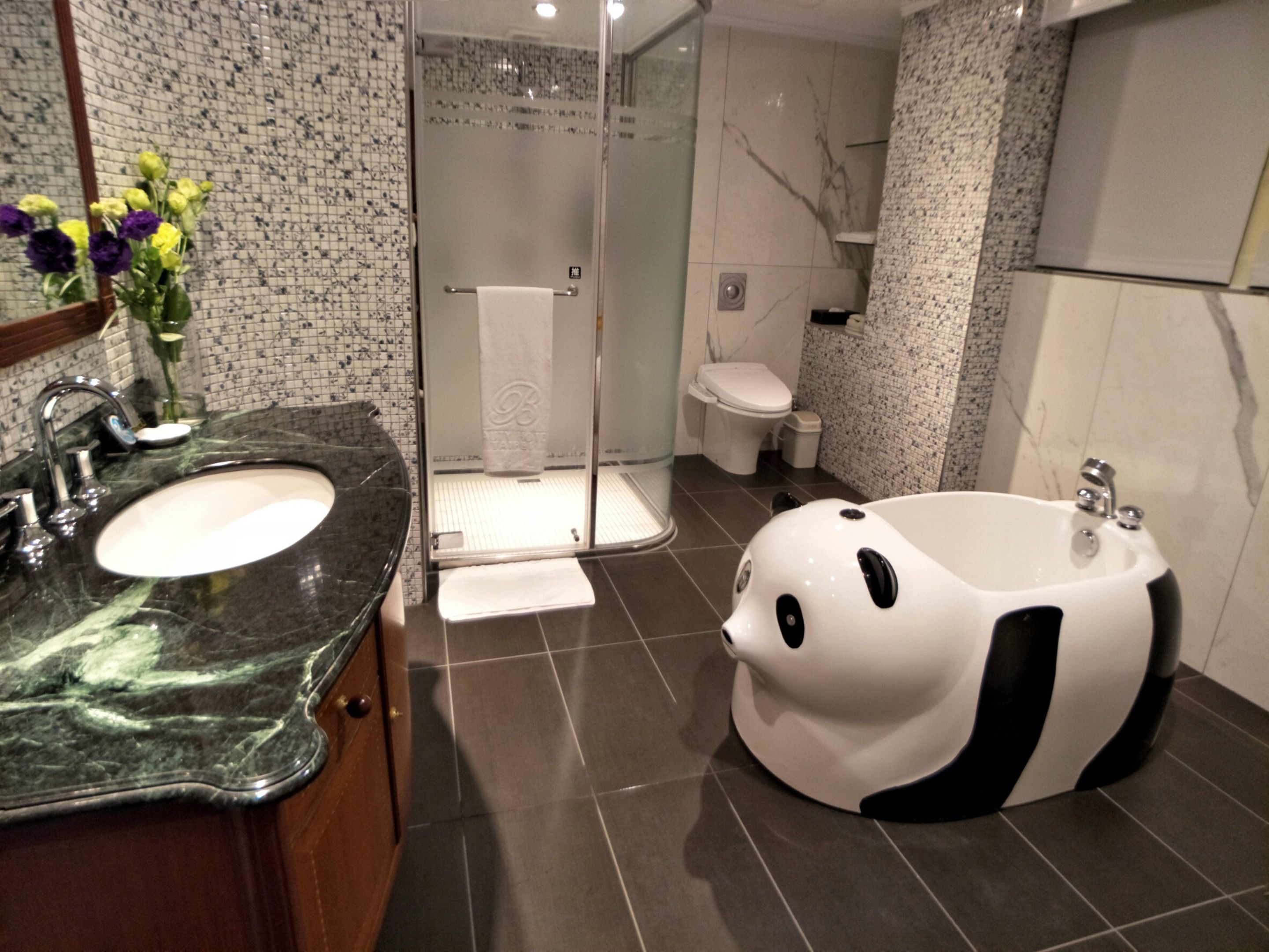 A bathroom with a black and white bathtub, a sink, and a shower.