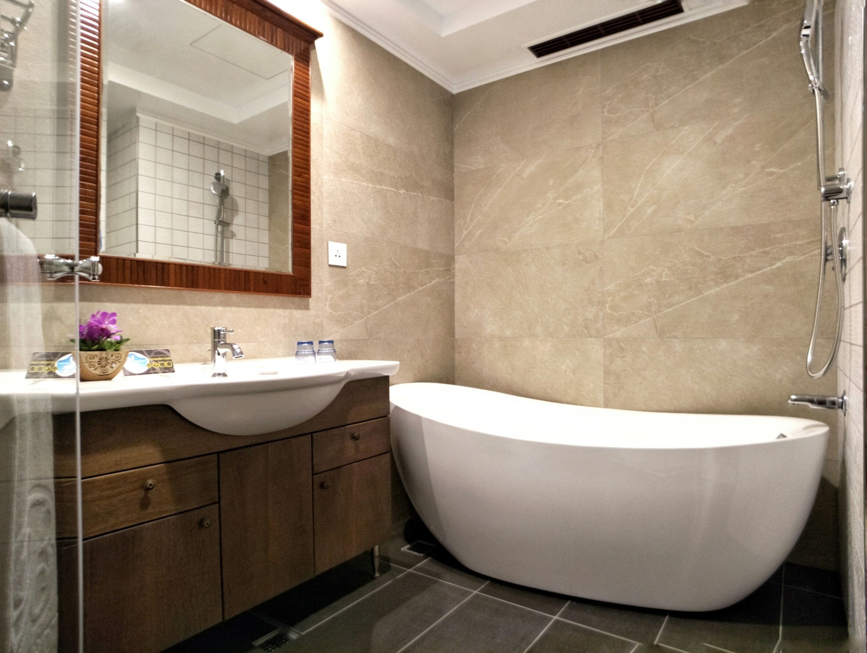 A modern bathroom with a freestanding bathtub, a vanity with a mirror, and a shower area.