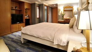 A hotel room with a large bed, wooden wardrobe, television, and a desk with a lamp. - Taipei Star Beauty Resort Hotel (Taipei)
