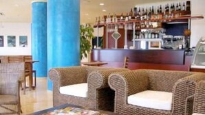 A lobby with wicker sofas, a coffee bar, and a reception desk.