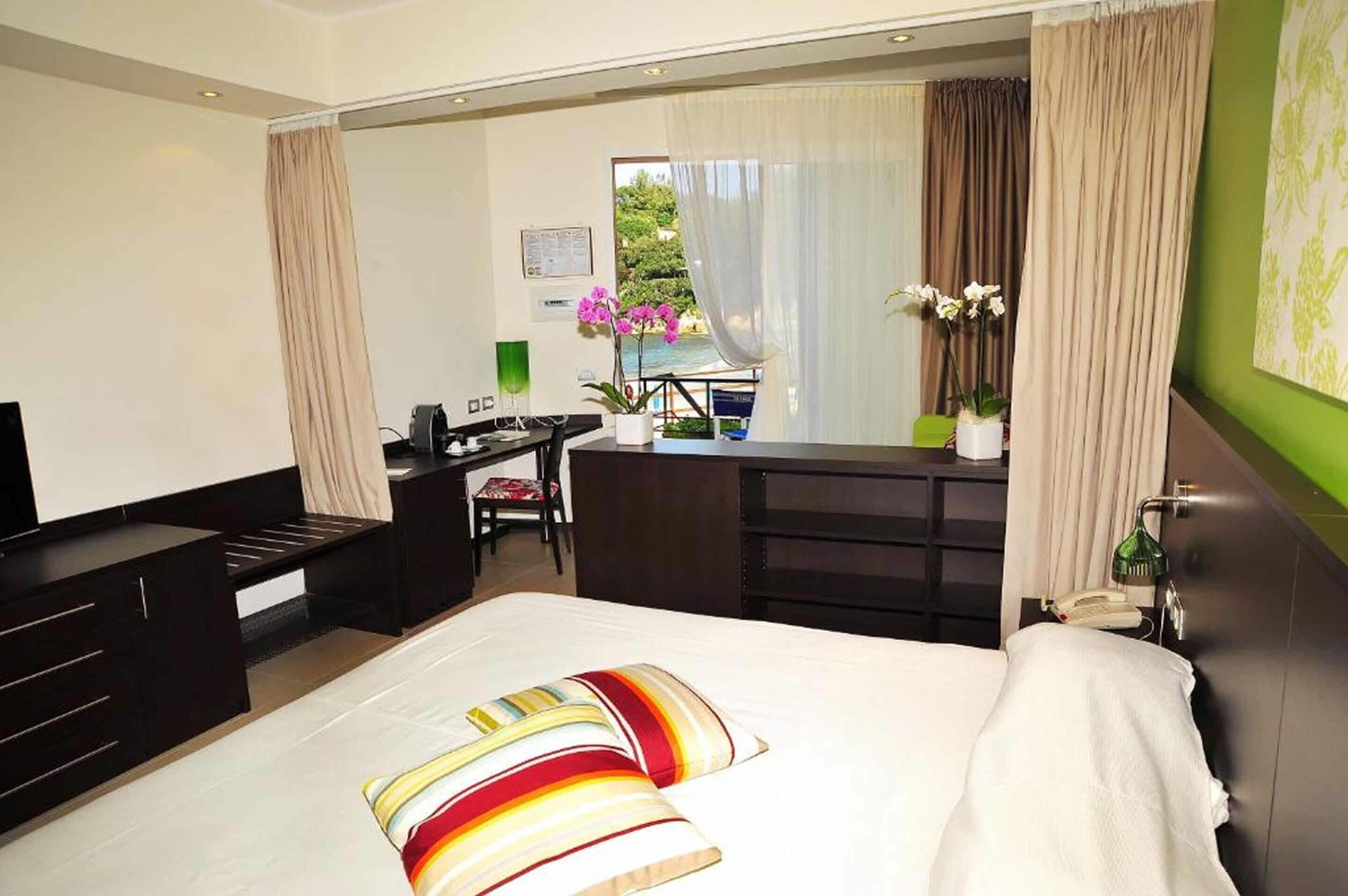 Habitación de hotel moderna con cama, escritorio, silla y vistas al exterior.