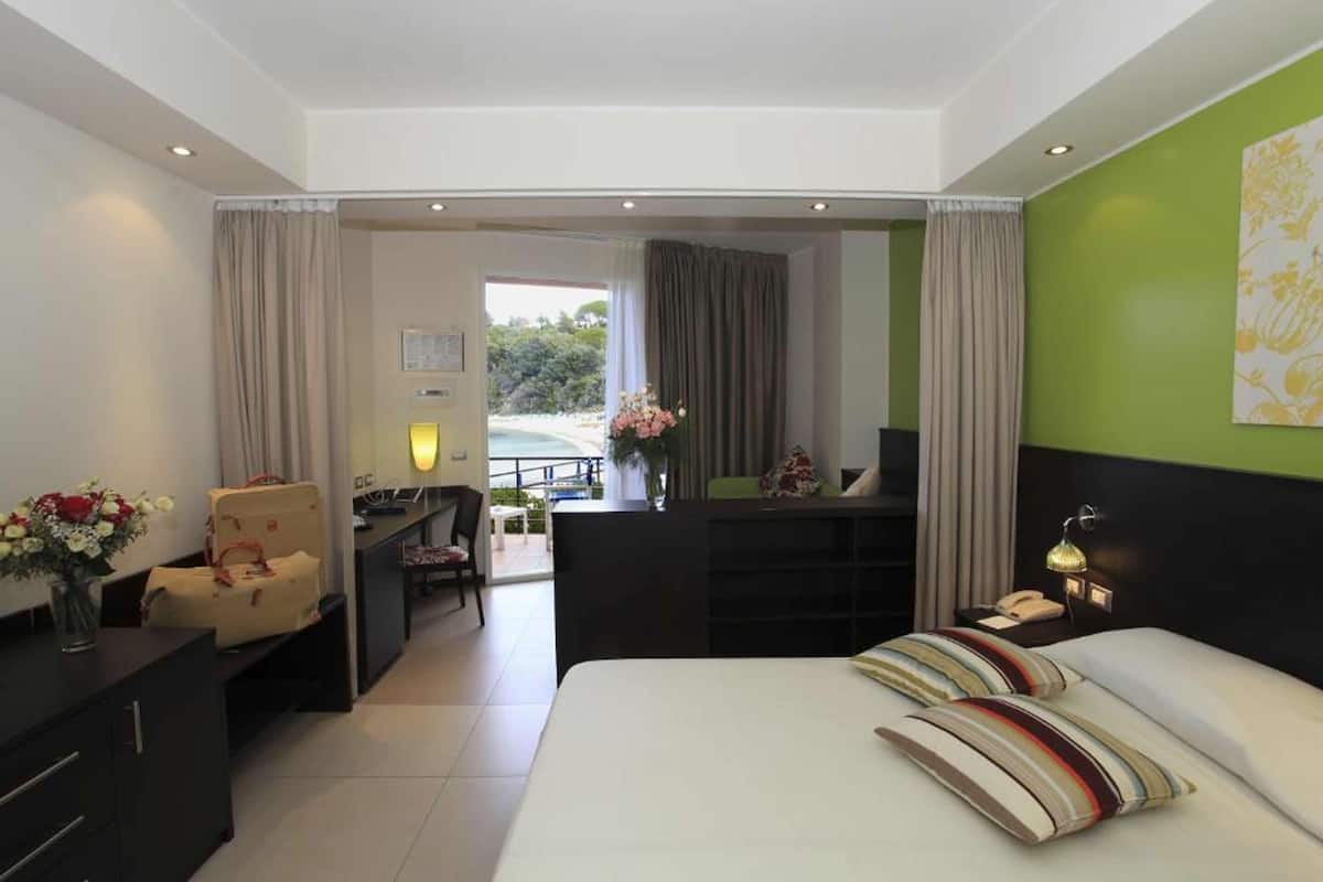 A hotel room with a bed, desk, and a view of the outdoors.