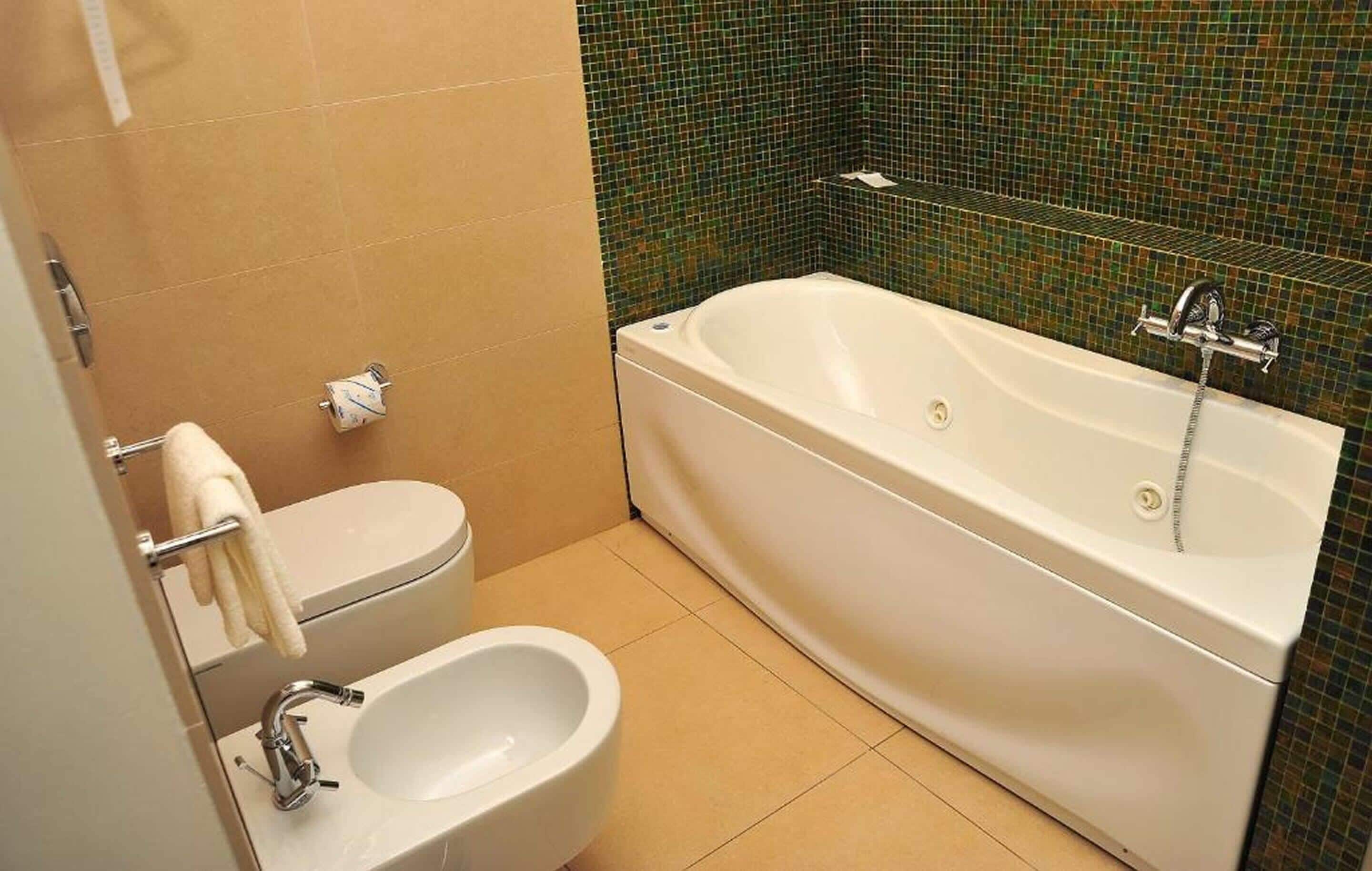 A bathroom with a bathtub, toilet, and sink.