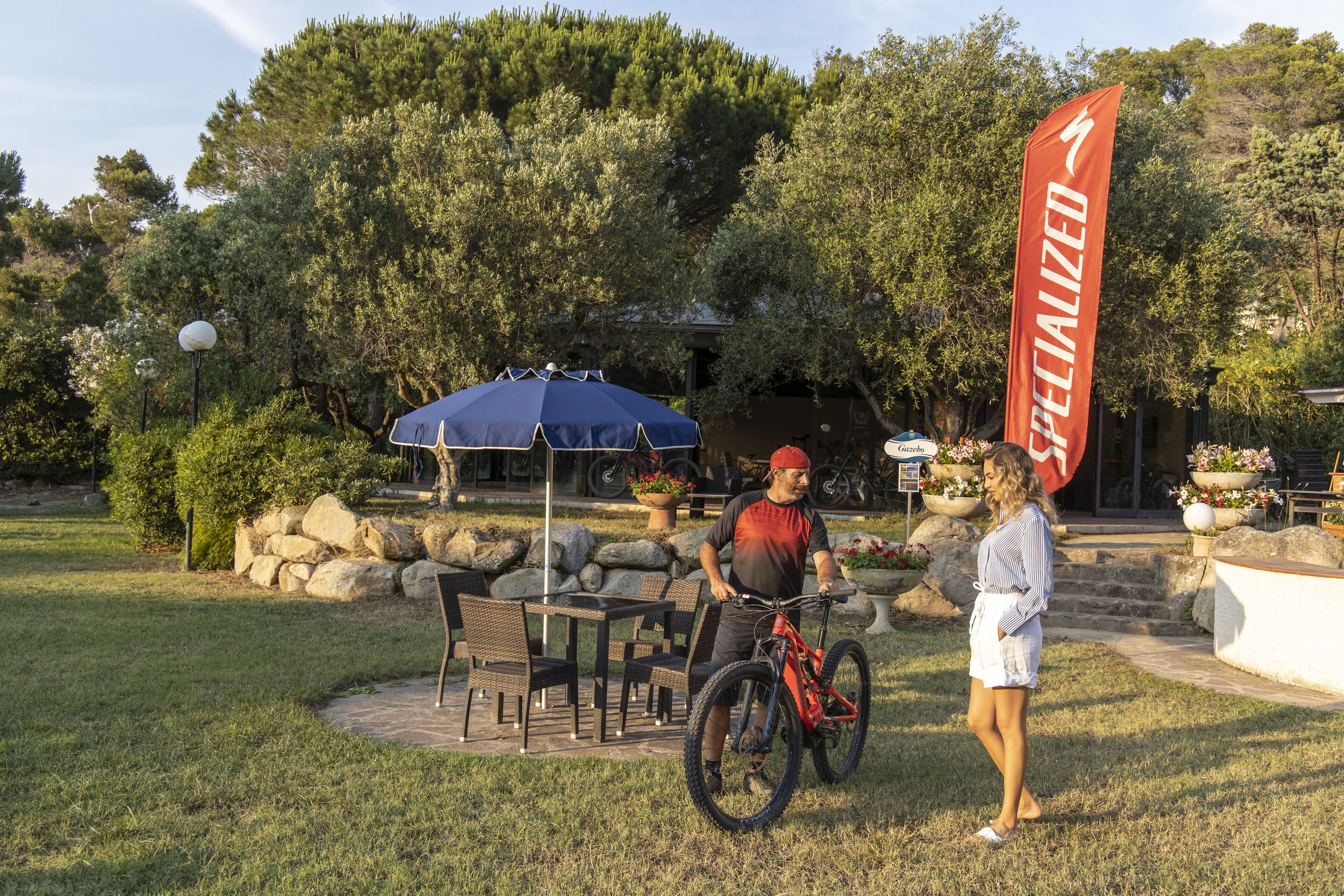 A patio area with outdoor seating, a bicycle, and a flag.