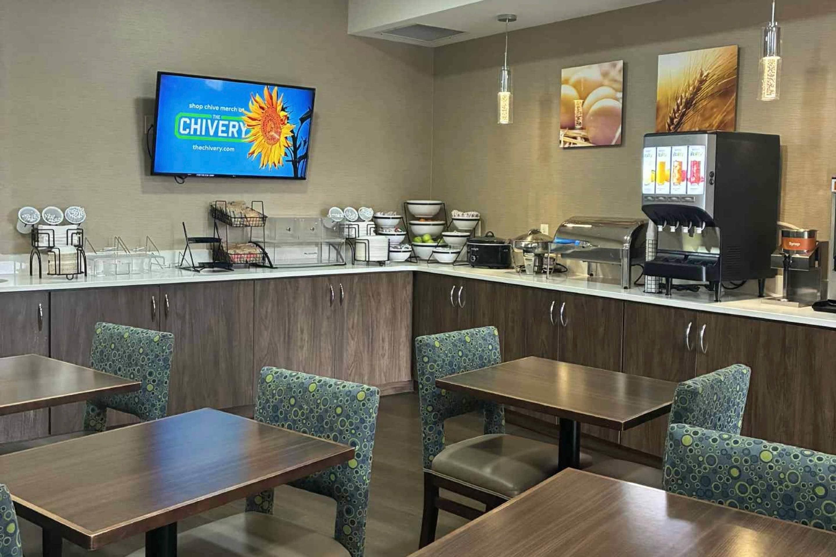 A hotel restaurant with a counter, seating, and a coffee machine.