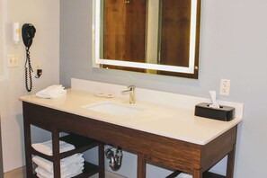 Enjoy a refreshing bathroom experience with a large mirror, sink, and vanity, plus a convenient hairdryer.