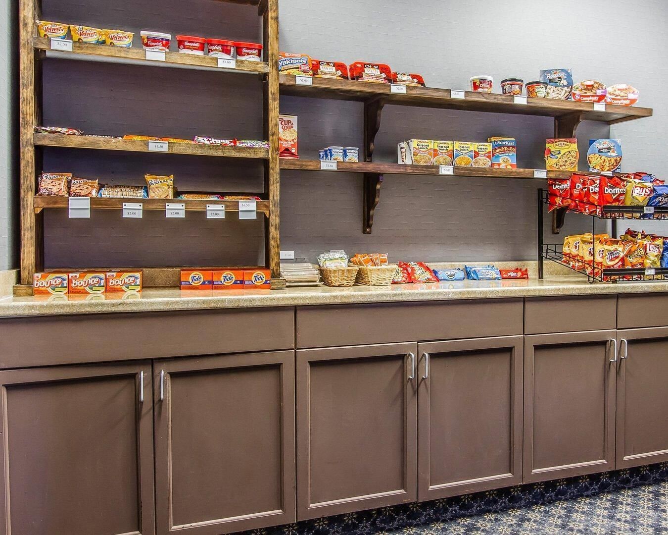 A snack bar with shelves stocked with various snacks and drinks, including chips, cookies, and beverages.