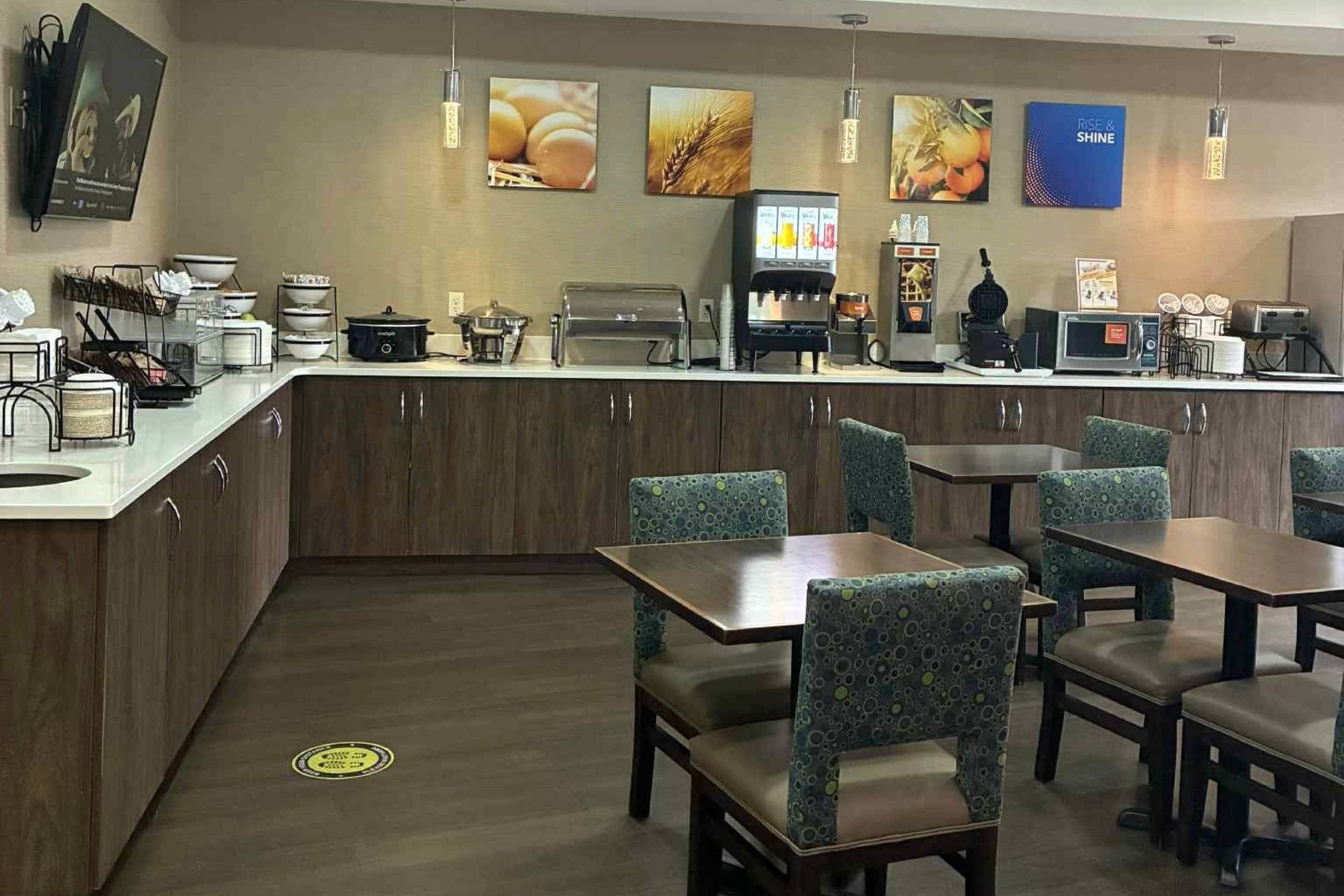 A restaurant with a counter, seating area, and various kitchen appliances.