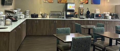 A restaurant with a counter, seating area, and various kitchen appliances.