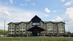Un hôtel à plusieurs étages, doté d’une entrée principale et de nombreuses fenêtres.