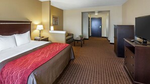 A hotel room with a large bed, a desk, a TV, and a door leading to a hallway. - Comfort Inn & Suites Regional Medical Center (Abilene)